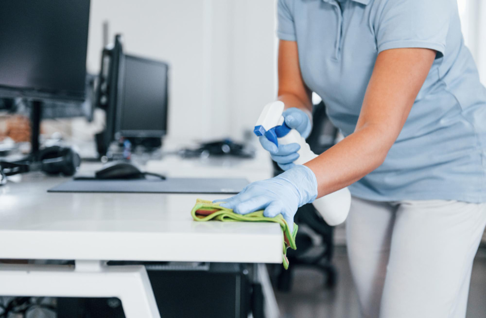 vista cerca mujer guantes protectores que limpian mesas oficina