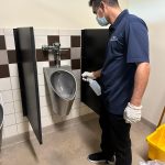 Bathroom cleaning, men cleaning office toilet.