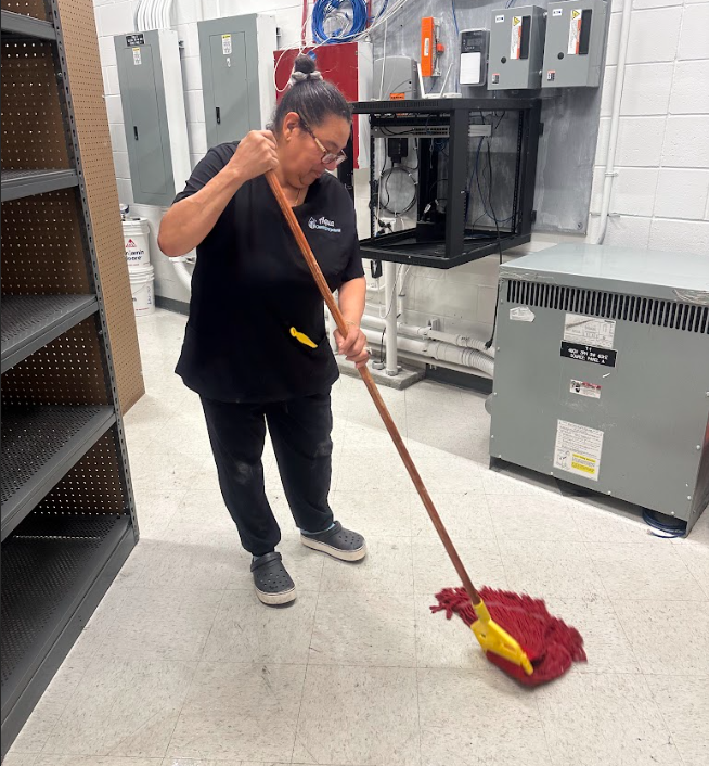 Janitorial service performed by woman wiping floors of a business building.