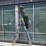 Women performing commercial cleaning service, cleaning windows of a business.