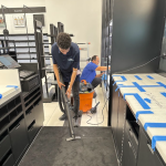 Post construction cleaningbeing performed, young man vacuuming carpet.